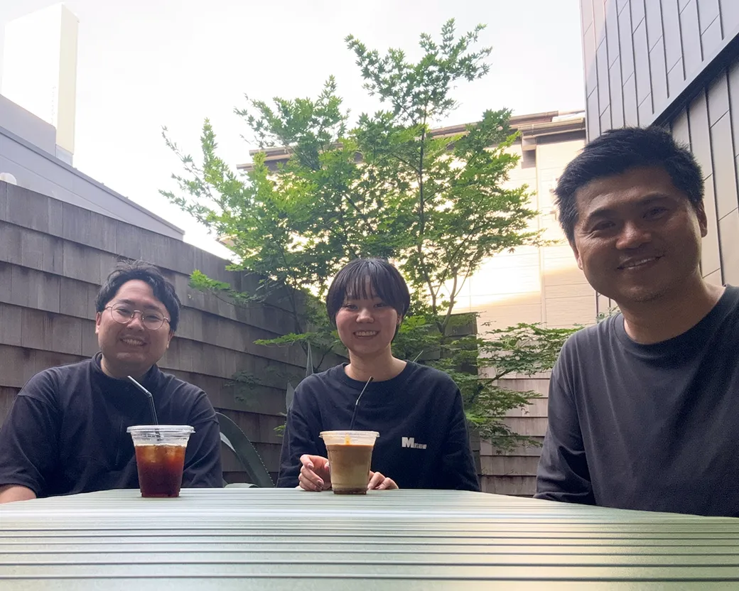 代表と社員二人がカフェで談笑している写真。